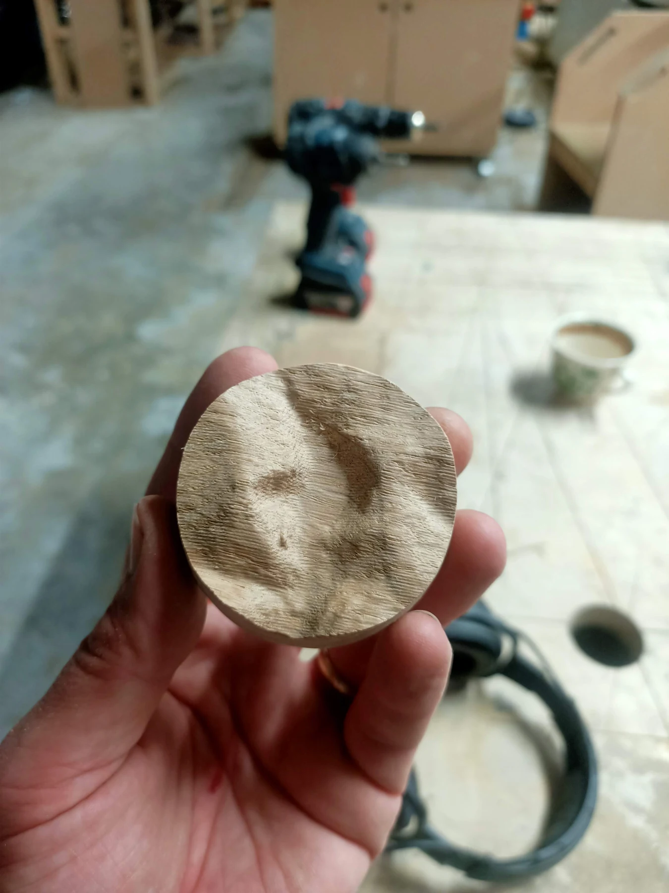 A small timber terrain piece held in a hand