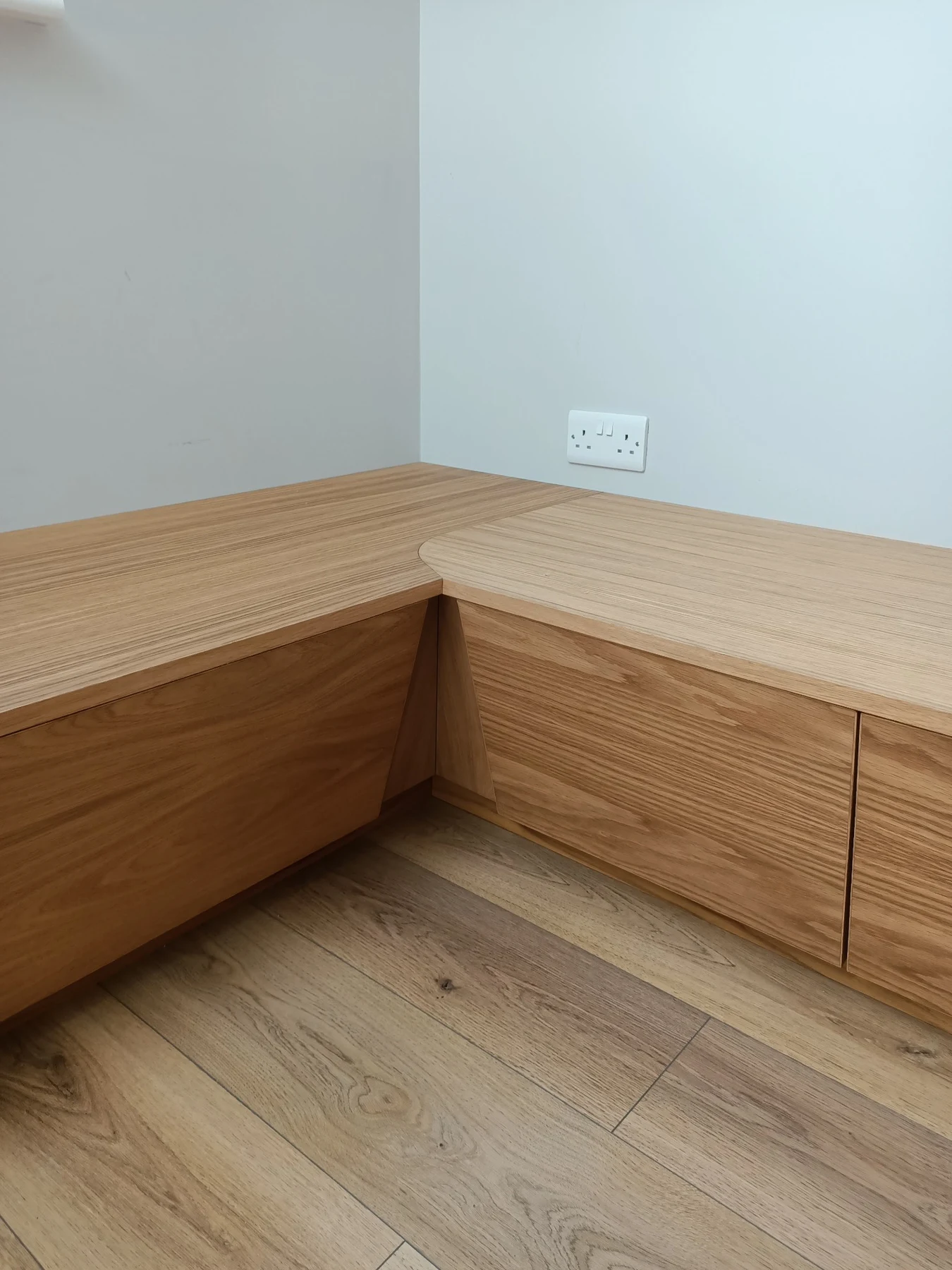 Bench tops meeting at the corner, with a curved junction above the storage