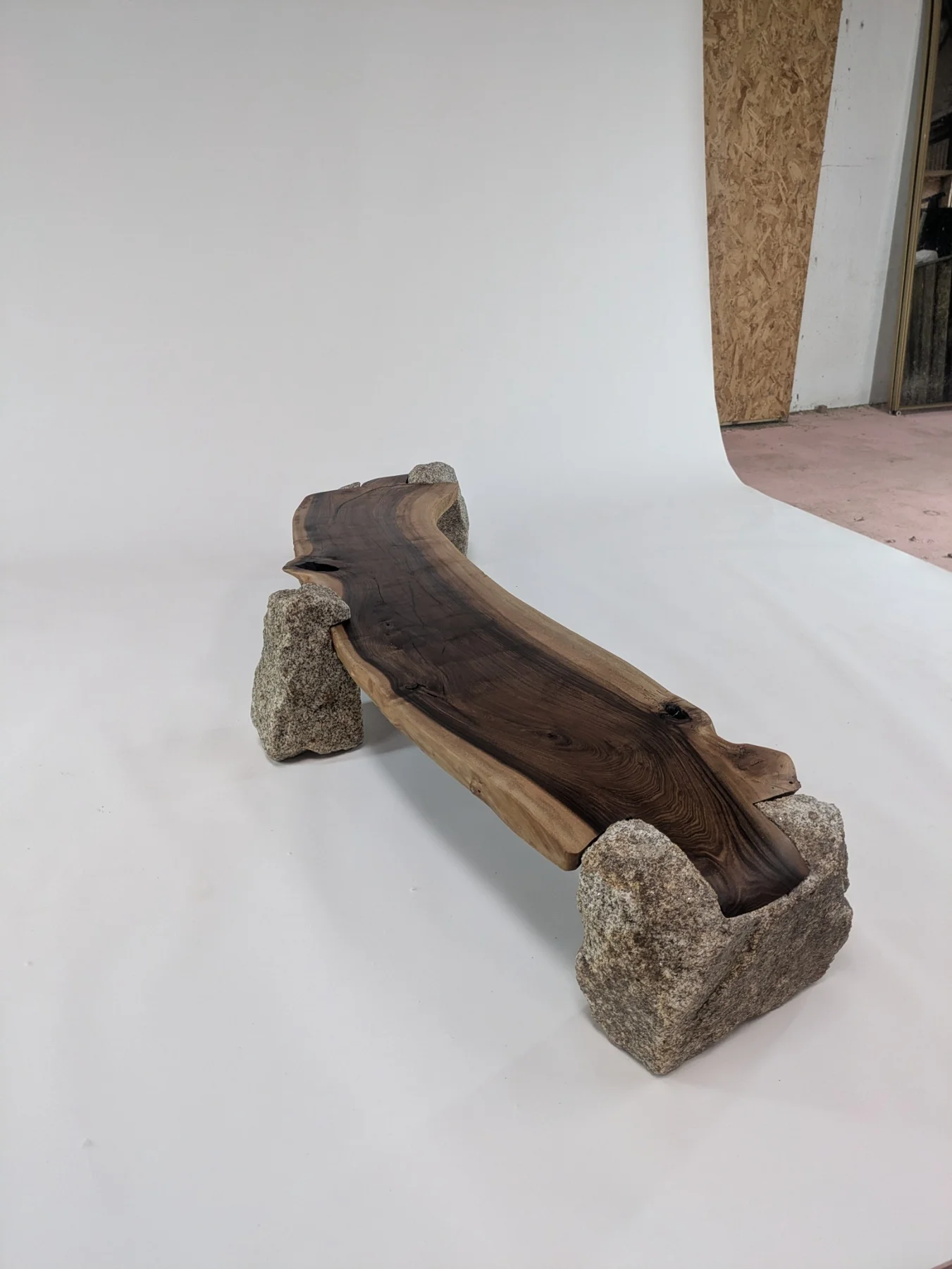 An angled view along the walnut slab and its three granite supports