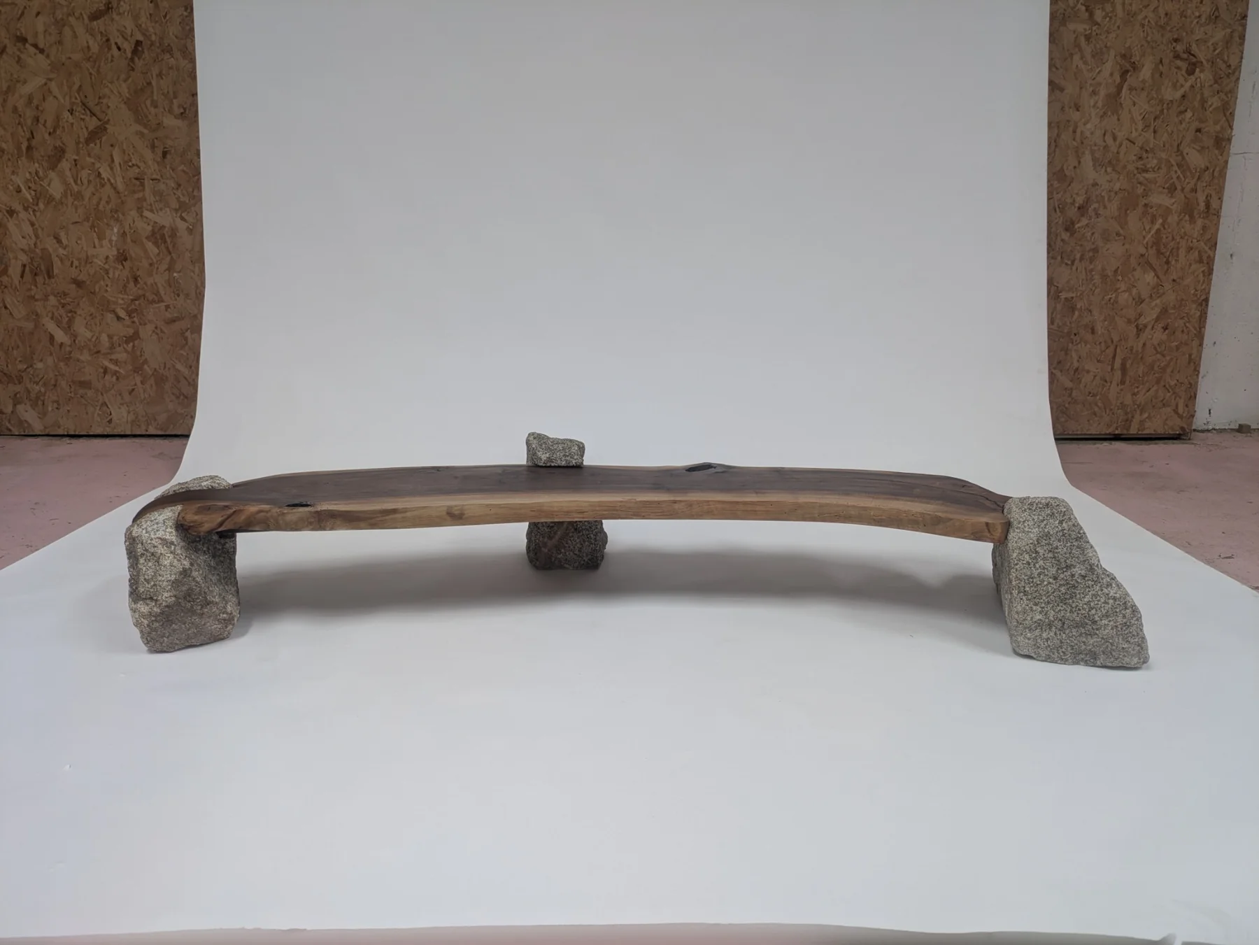 The complete walnut bench held between three pieces of Wicklow granite