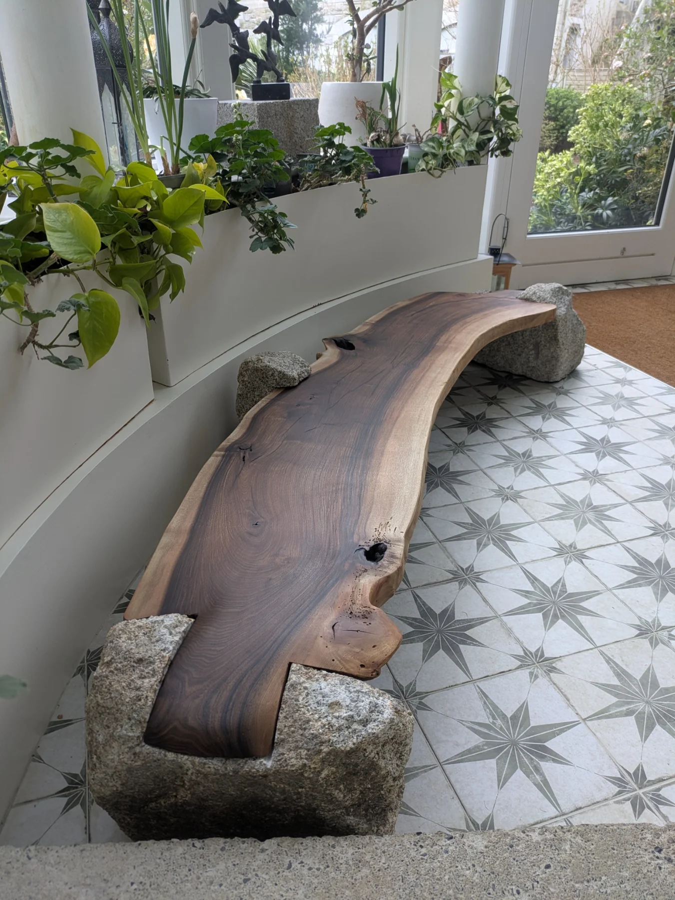 The walnut bench and granite supports viewed along the window