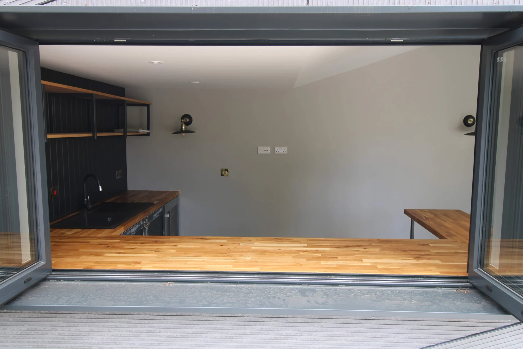 View through the open windows across the oak worktop into the home bar