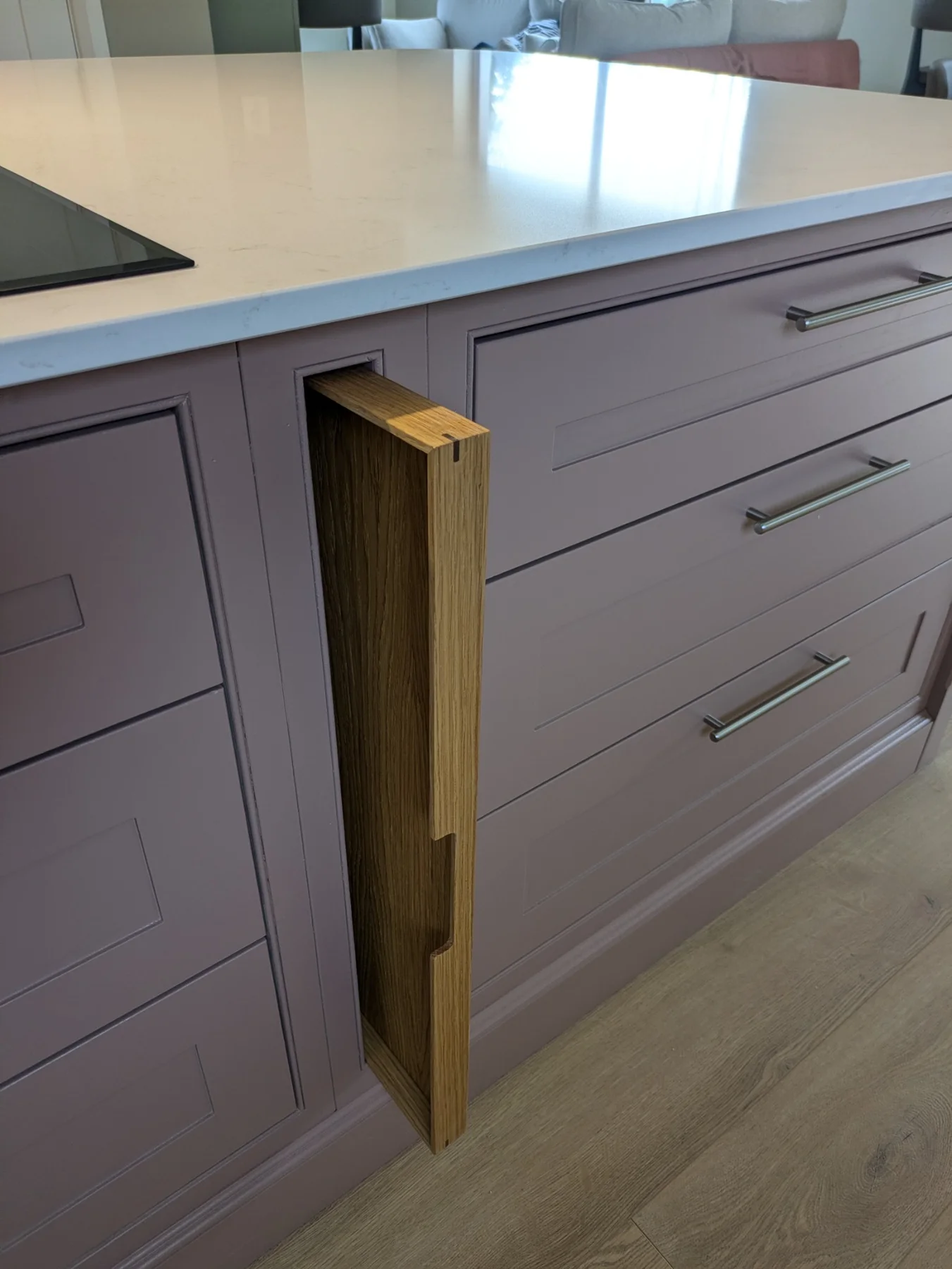 A fitted oak tray partly pulled out of its slot in the kitchen island