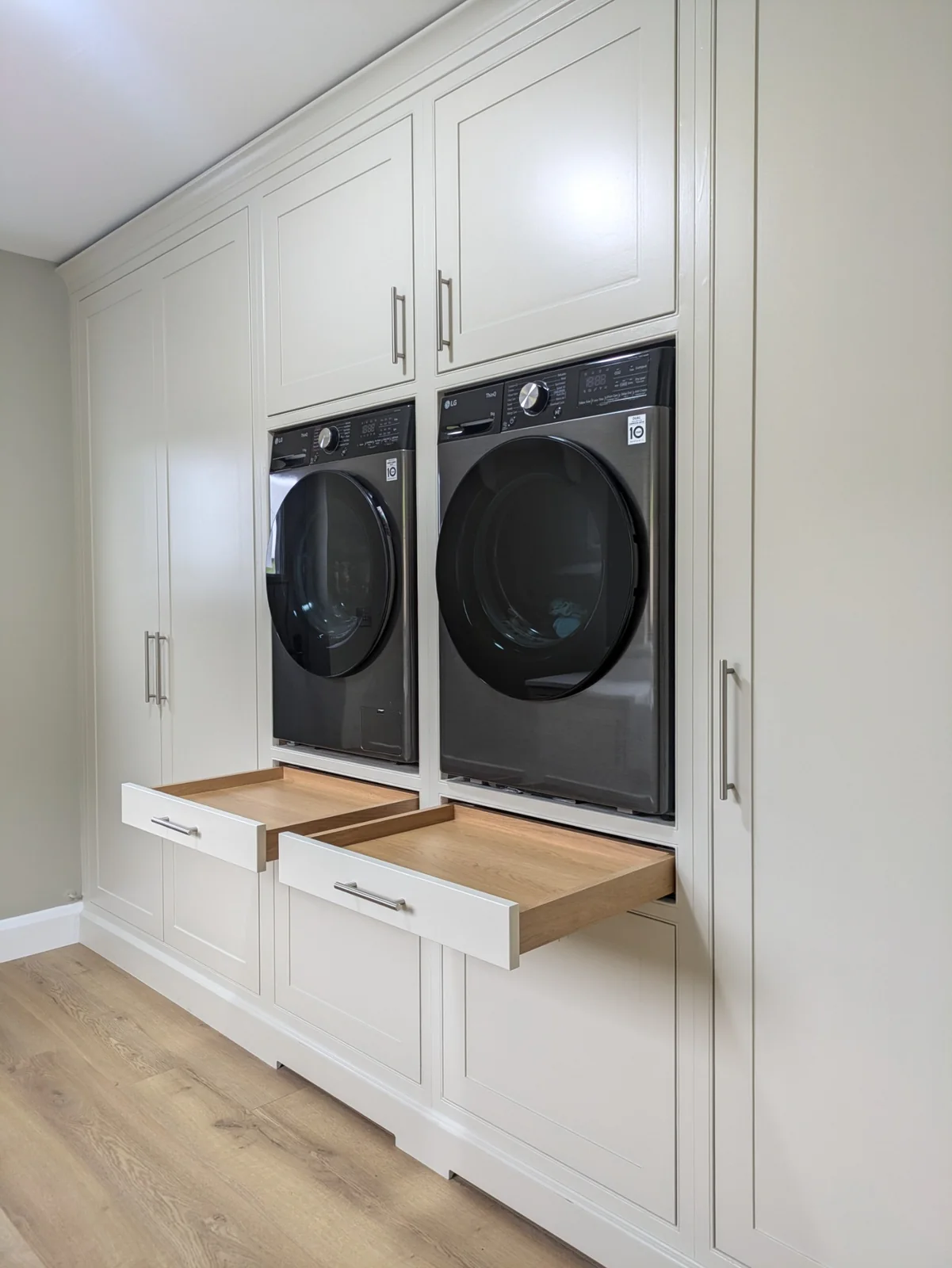 Raised washing machine and dryer with pull-out oak shelves beneath