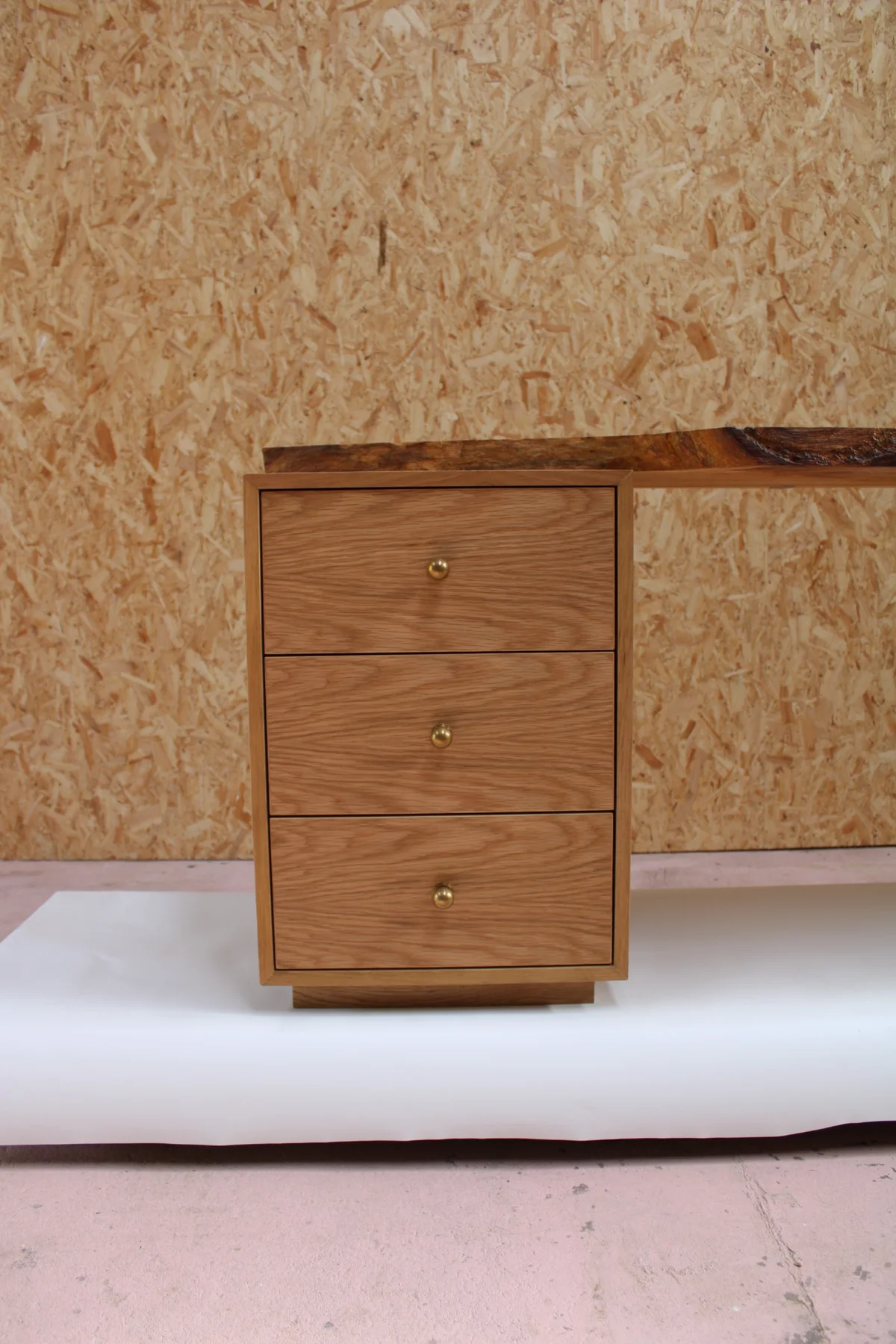 The three-drawer oak cabinet supporting the other end of the desk