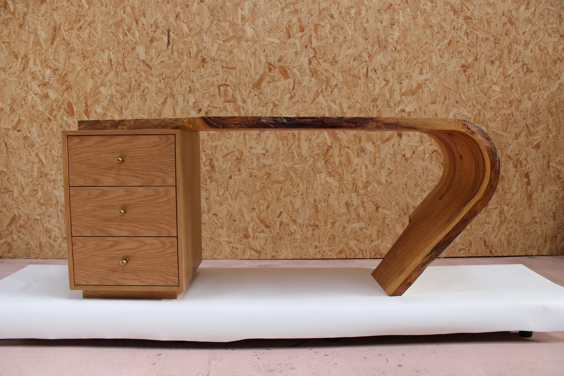 The complete oak desk showing the long natural slab sweeping into a curved end