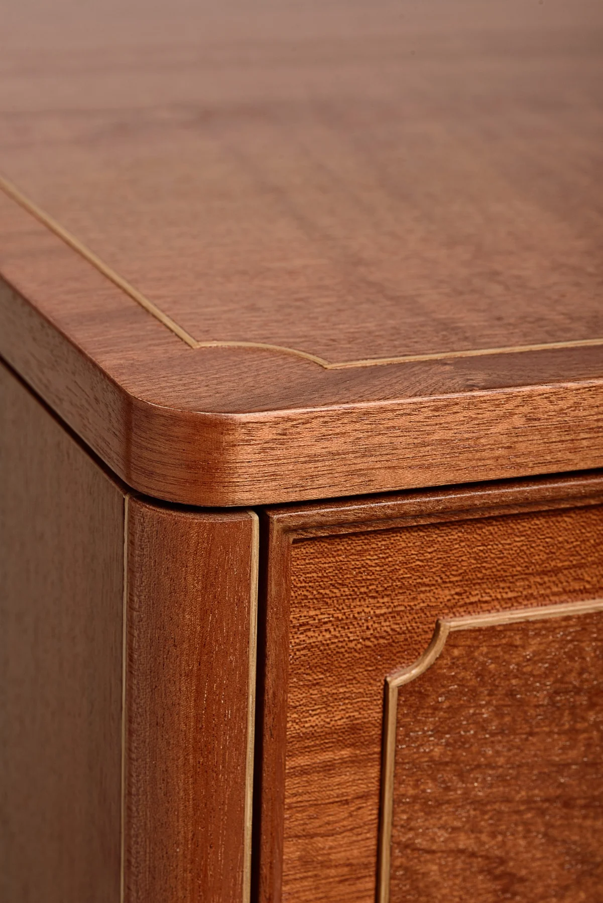 The rounded Sapele trim and oak inlay at the corner of the dresser top