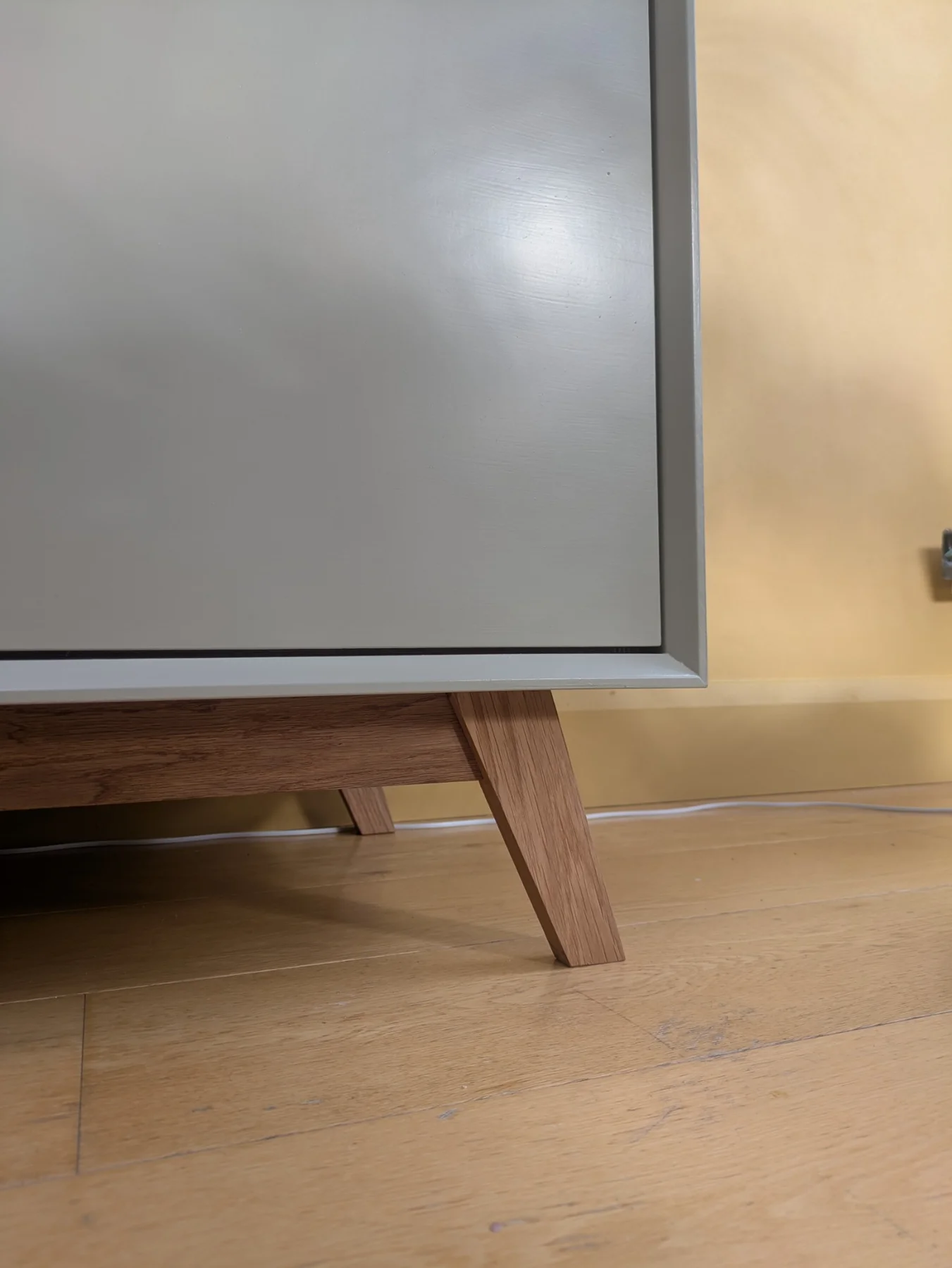 A solid oak leg supporting the painted sideboard, with the oak reveal above