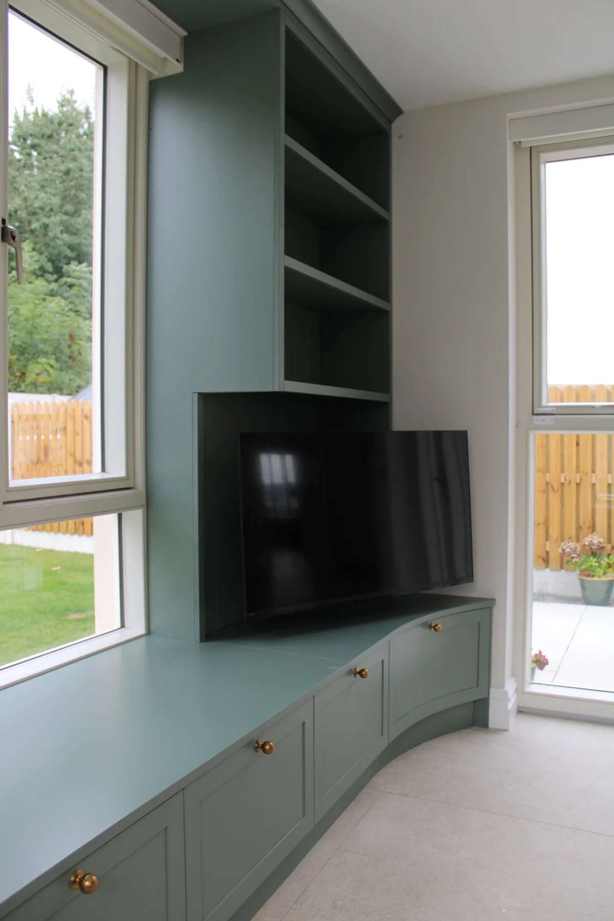 The bookshelf and TV unit wrapping around onto the right-hand wall