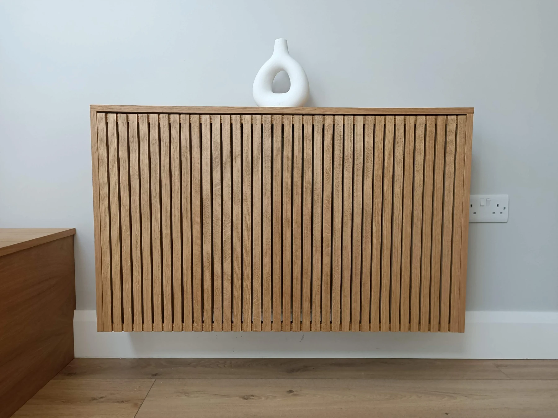 Wall-mounted timber radiator cover with vertical slats