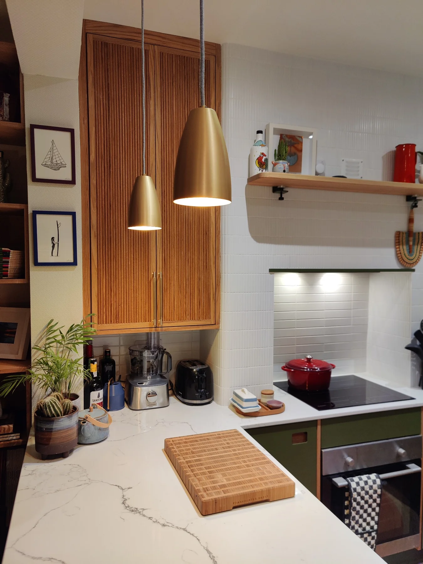 Reeded oak cupboard doors above the kitchen worktop with brass pendant lights